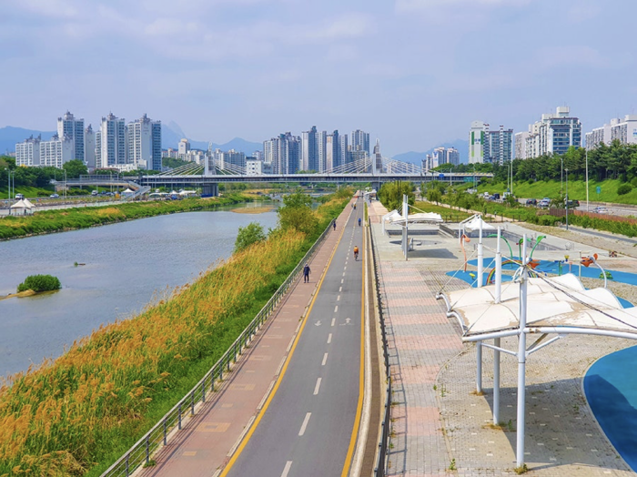 A Seoul stream, Joongnangcheon walking and cycling path in a daylight. Tall apartment buildings in the background.